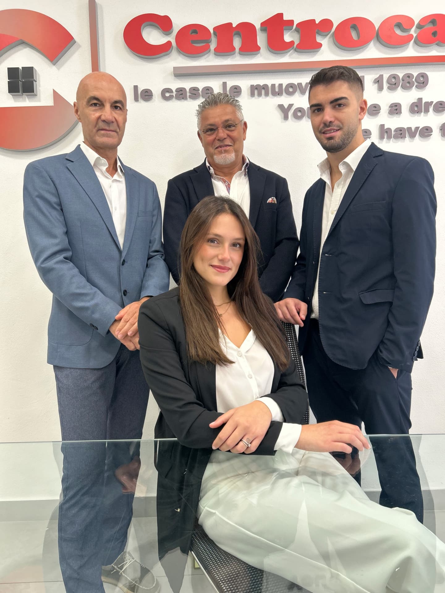 Il team CENTROCASA davanti al logo dell'agenzia